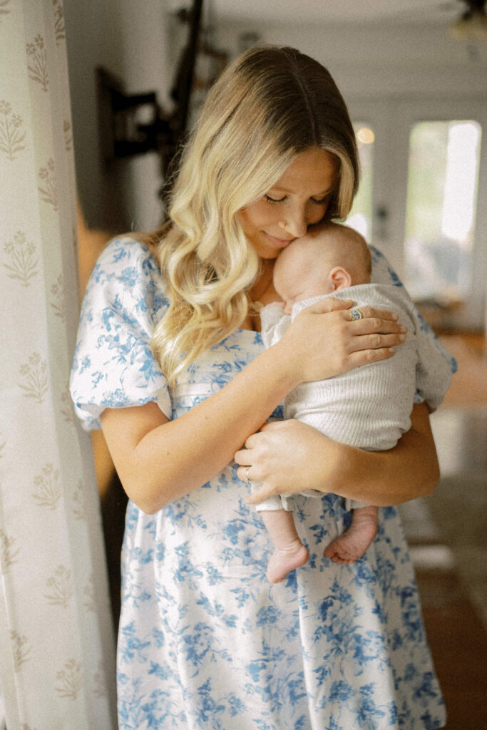 Mom cuddles her newborn baby on her chest during her main line newborn photo session