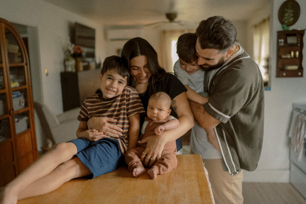 family cuddles in their kitchen with their 3 little boys during their mechanicsburg photographer session