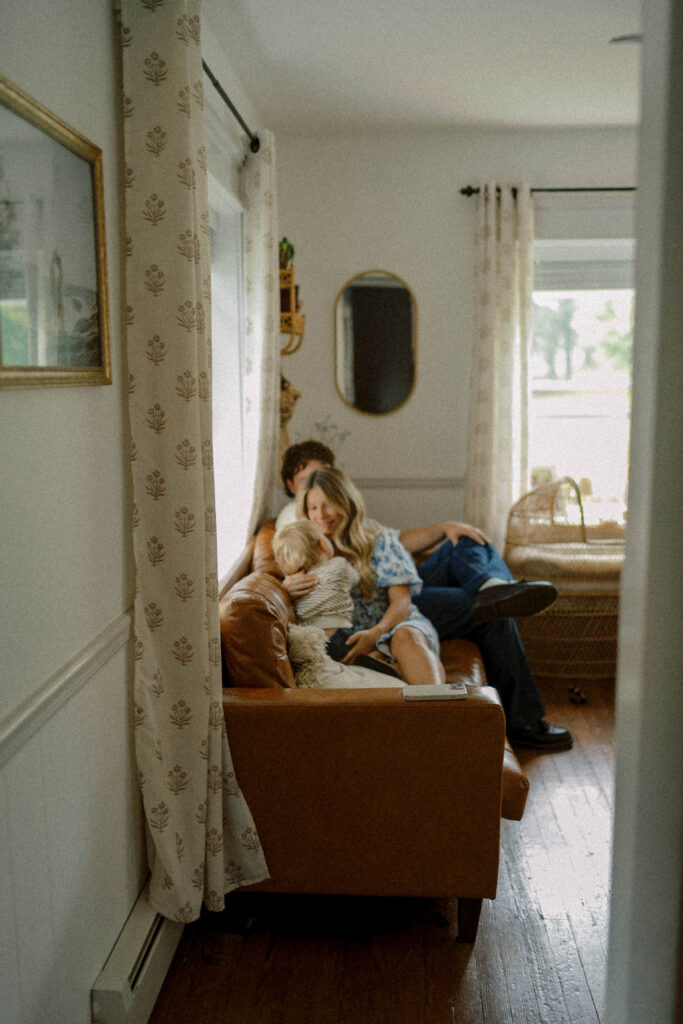 family sits on their couch while they enjoy their fall family photos in philadelphia session
