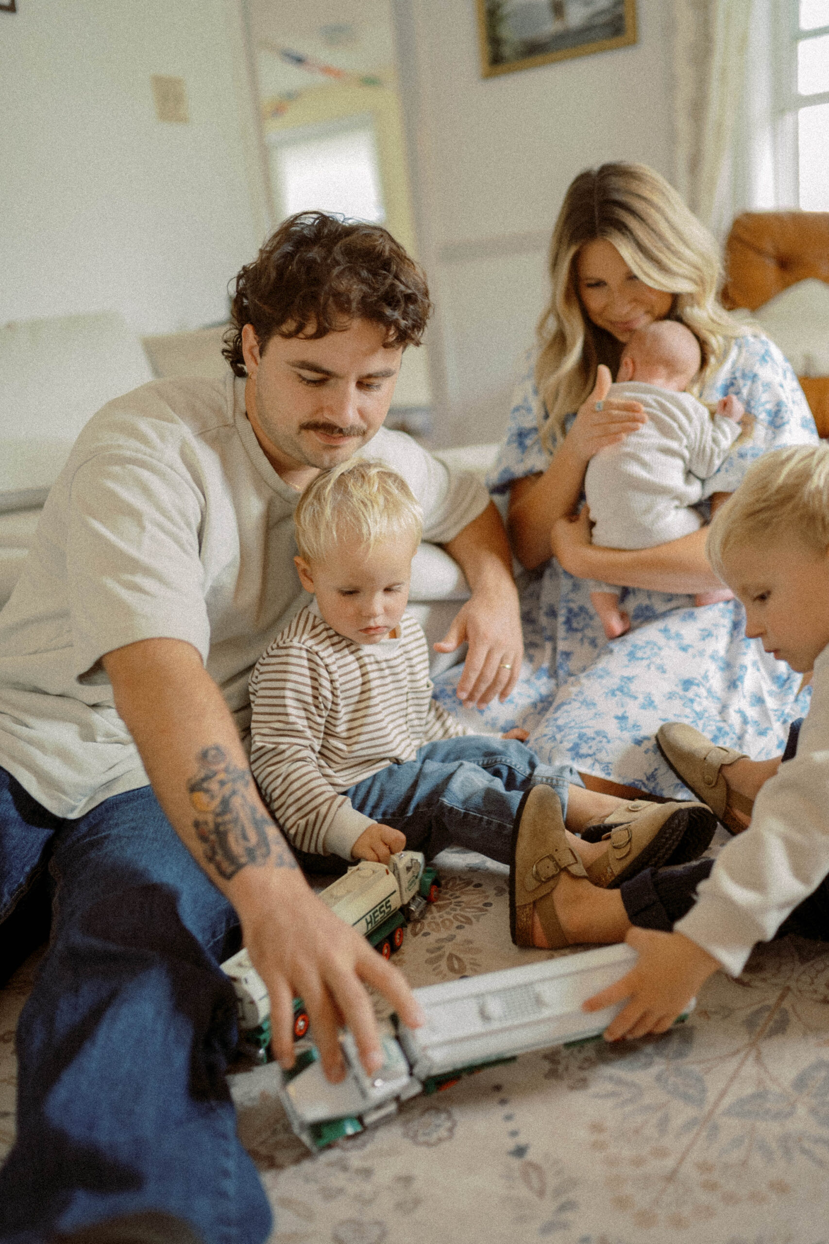 family sits in their living room playing with toys during their family photoshoot at home