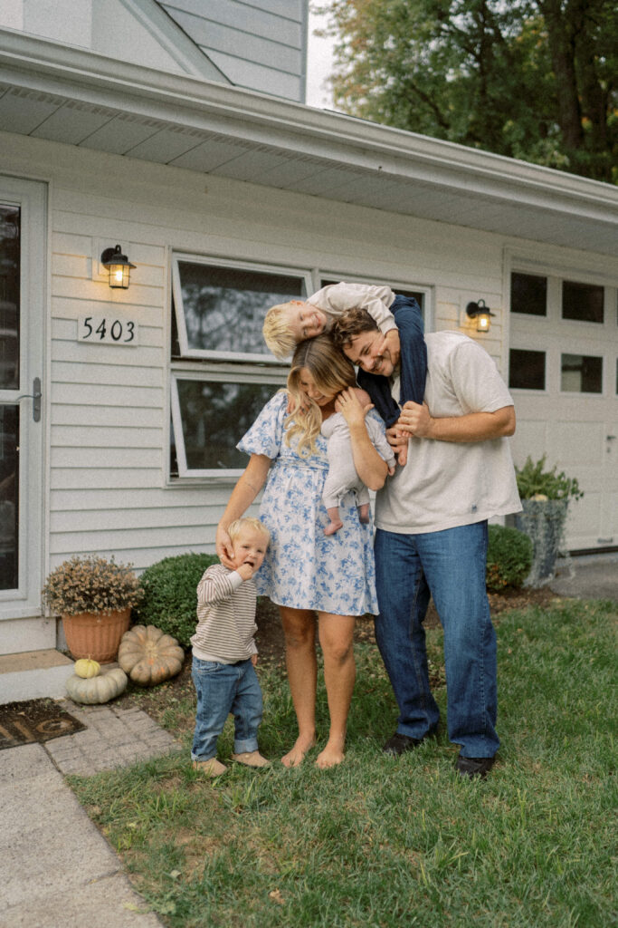 family poses outside their home family photoshoot at home