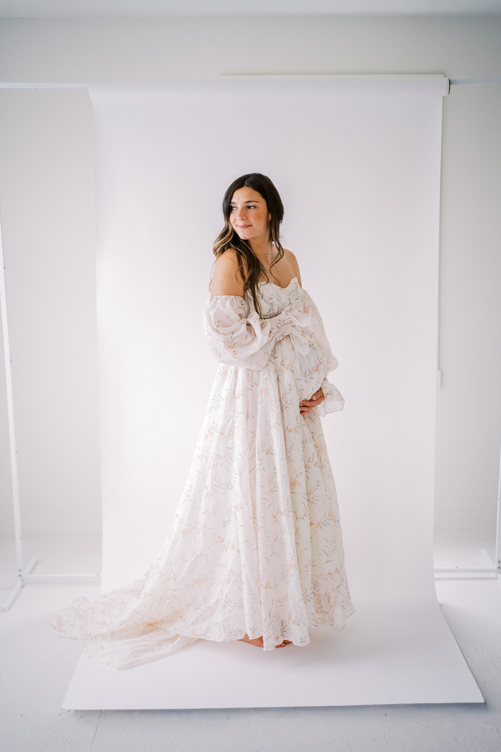 Pregnant Mom posing in a studio in front of a white backdrop